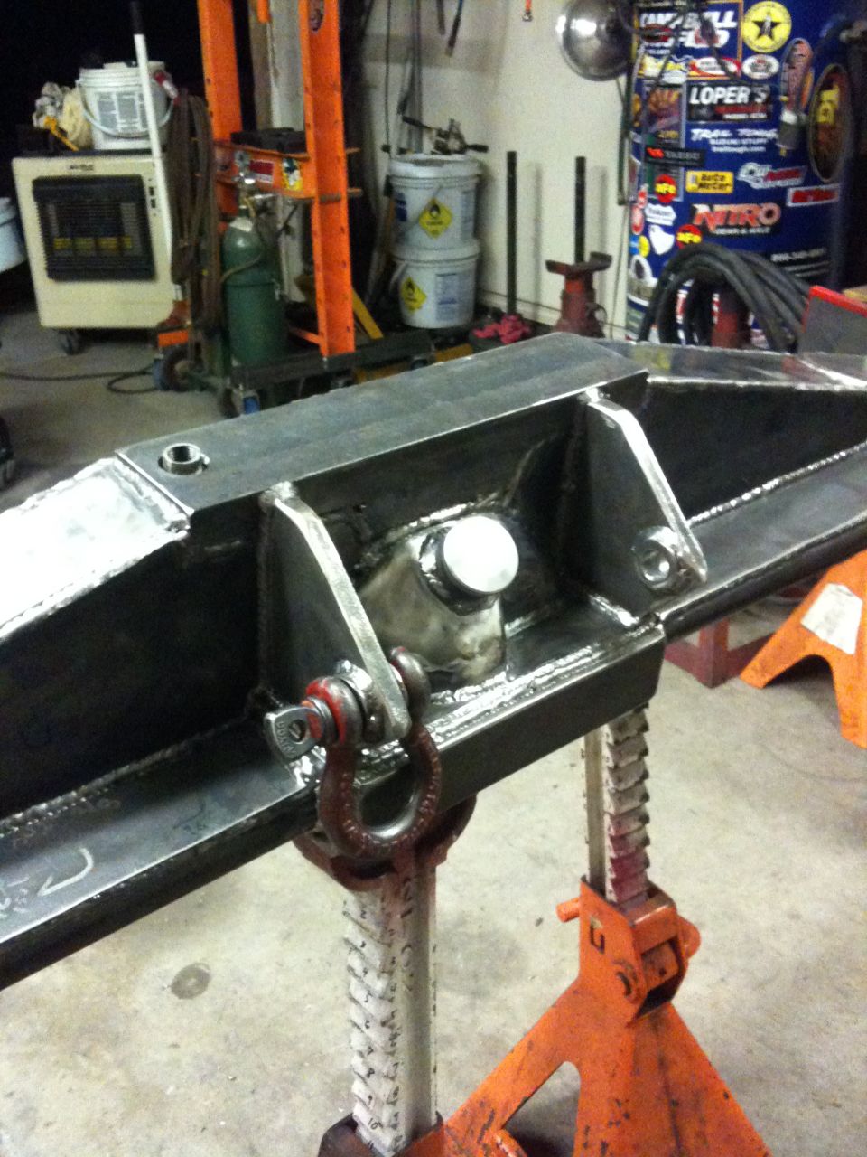 Fabricated steel axle housing with shackle mount, supported by jack stands