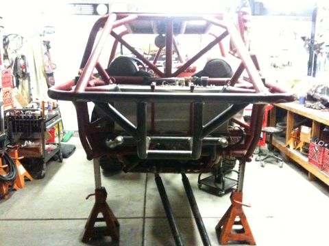 Suzuki Samurai - This custom buggy's rear chassis is visible while supported by jack stands in a workshop.