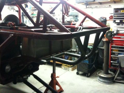 Suzuki Samurai - Custom tube chassis with a red roll cage and black tubing is visible in a workshop setting.