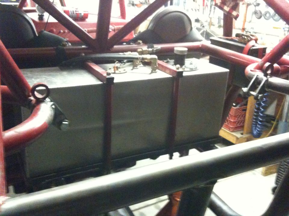 Custom fuel tank mounted within a red roll cage structure