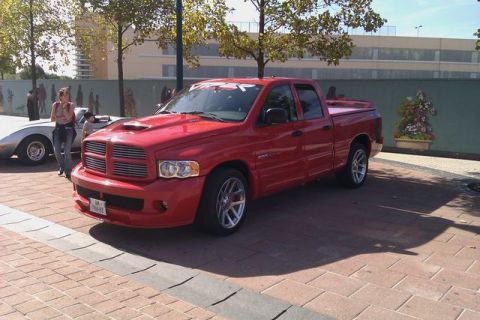 1991 Ford LTD Crown Victoria - A red pickup truck is parked on a brick surface with a silver car in the background.