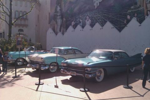 1991 Ford LTD Crown Victoria - A line of vintage cars, including a turquoise coupe with tail fins, are displayed outdoors.