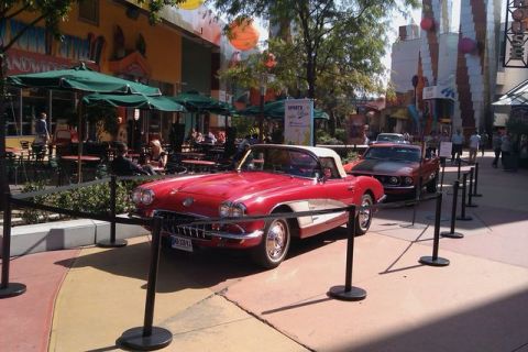 1991 Ford LTD Crown Victoria - A red 1958 Chevrolet Corvette convertible is displayed outdoors with another car behind it.