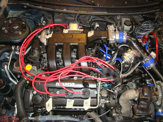 Mazda engine with red spark plug wires and turbocharger components