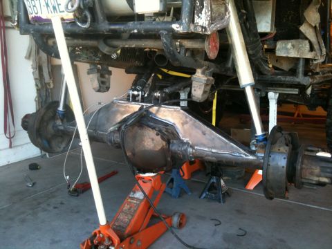 1966 Ford Bronco - Custom fabricated rear axle assembly undergoing work, supported by jack stands.