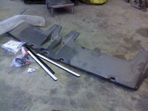 1995 Ford Bronco - Gray front bumper cover for a Ford Bronco, shown with associated trim and hardware.