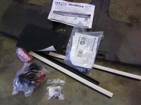 1995 Ford Bronco - Collection of automotive parts and installation instructions laid out on a concrete floor.