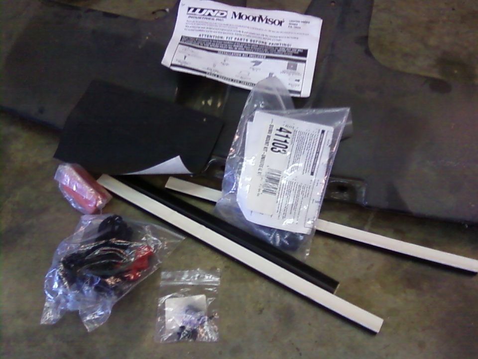 Various car parts including a Lund Moonvisor instruction sheet and a bag with part number 41103