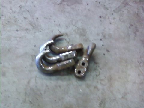 1995 Ford Bronco - Several metal tow hooks and a bracket are shown on a concrete floor.