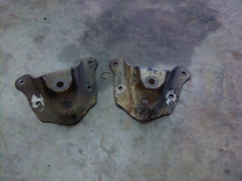 1995 Ford Bronco - Two metal brackets are shown resting on a concrete surface.