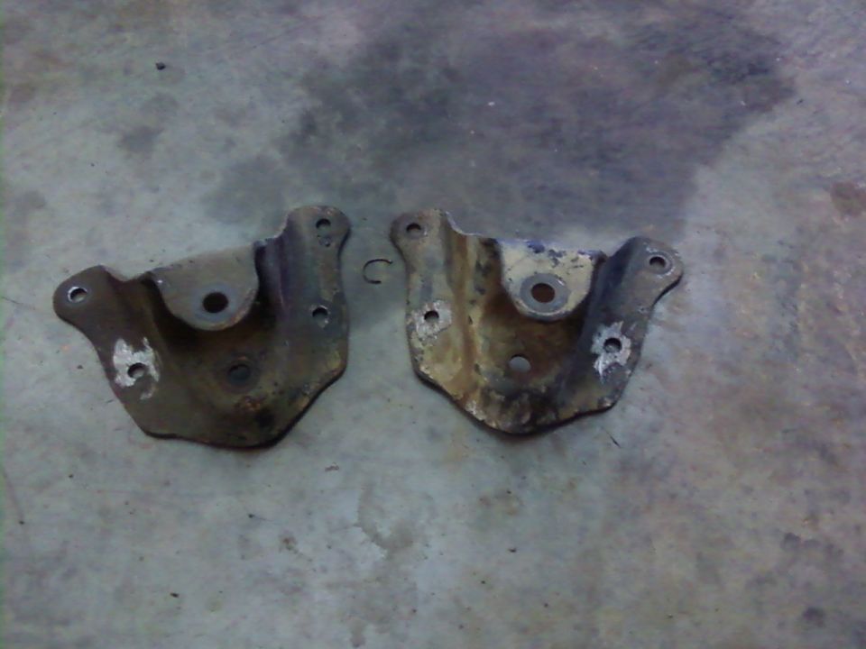 two rusty metal brackets on concrete floor