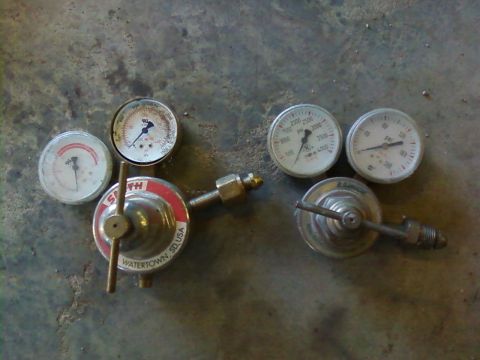 1995 Ford Bronco - Two pressure regulators with attached gauges are shown on a concrete surface. One regulator is labeled Smith, Watertown, SD, USA.