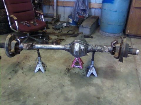 1995 Ford Bronco - Rear axle assembly supported by jack stands, showing differential and brake mounting points.