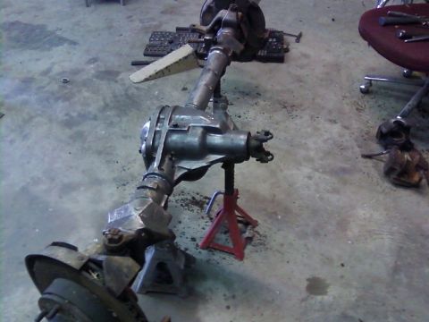 1995 Ford Bronco - A vehicle's front and rear axle assemblies are shown disassembled and supported by jack stands.