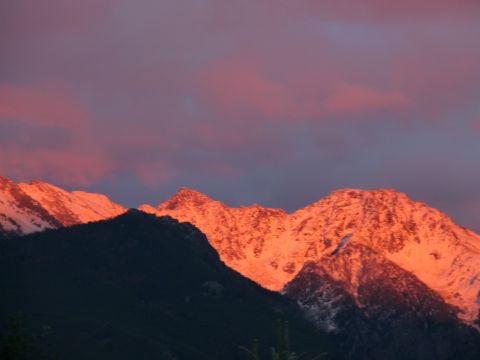 2006 Ford E350 - Mountain peaks glow with sunset light under a purple and pink sky.