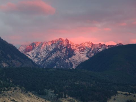 2006 Ford E350 - Mountain range bathed in the warm glow of a sunset, with snow dusting the upper slopes.