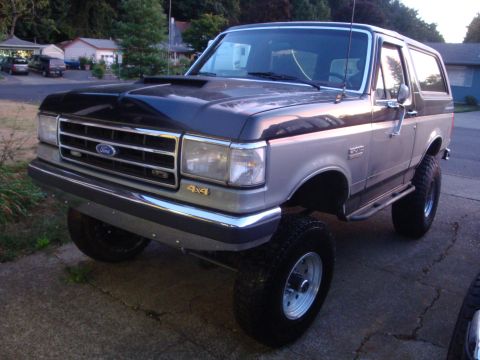 1989 Ford Bronco - This lifted 1989 Ford Bronco features a two-tone paint scheme and prominent 4x4 badging.