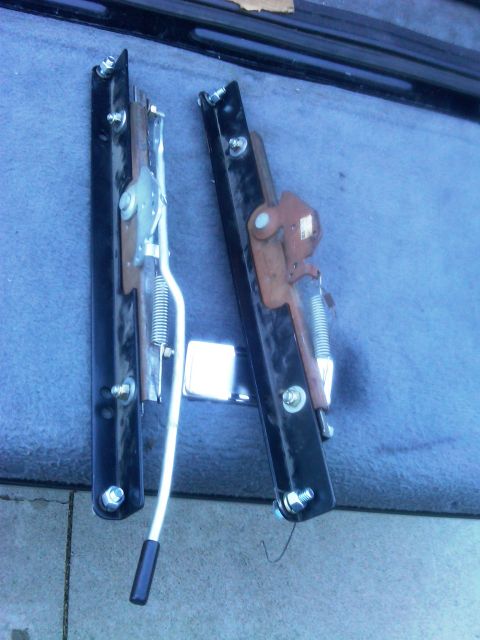 1986 Ford Bronco - Two seat sliders are shown, each with a black metal frame and visible springs.
