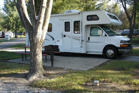 2005 Chevrolet Silverado 3500 - This RV is parked at a campsite, ready for an outdoor adventure. A picnic table and grill are set up nearby.