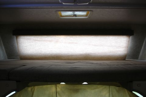 2005 Chevrolet Silverado 3500 - View of the sleeping loft area inside a vehicle, a skylight and blinds.