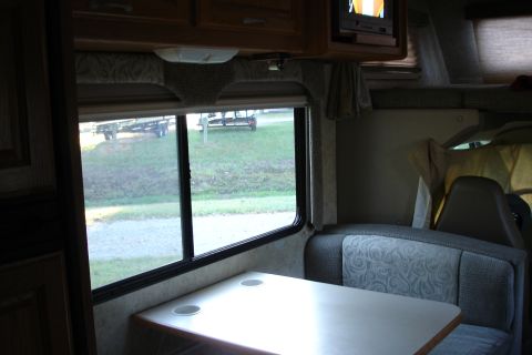 2005 Chevrolet Silverado 3500 - Interior view of an RV, looking out a window at parked trailers.
