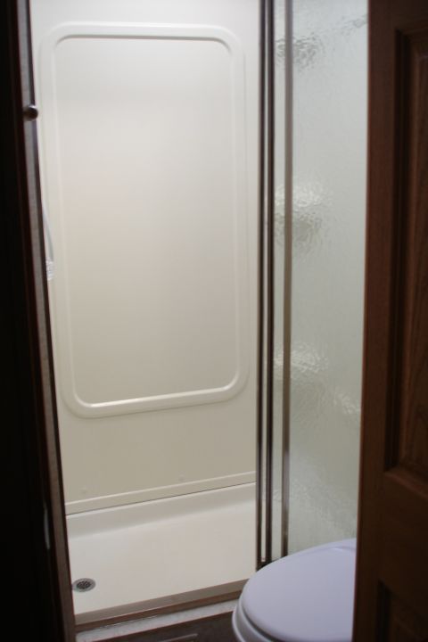 2005 Chevrolet Silverado 3500 - Interior view of a bathroom with a shower stall and toilet.
