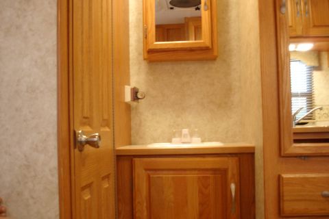 2005 Chevrolet Silverado 3500 - Interior of an RV showing a sink, cabinet, and door.