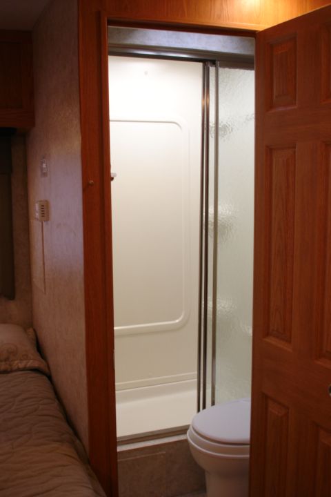 2005 Chevrolet Silverado 3500 - This RV interior features a compact bathroom with a toilet and a shower stall.