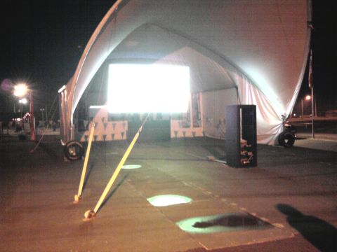 2005 Chevrolet Silverado 3500 - A nighttime scene shows a large tent structure with a bright screen, illuminated by lights.