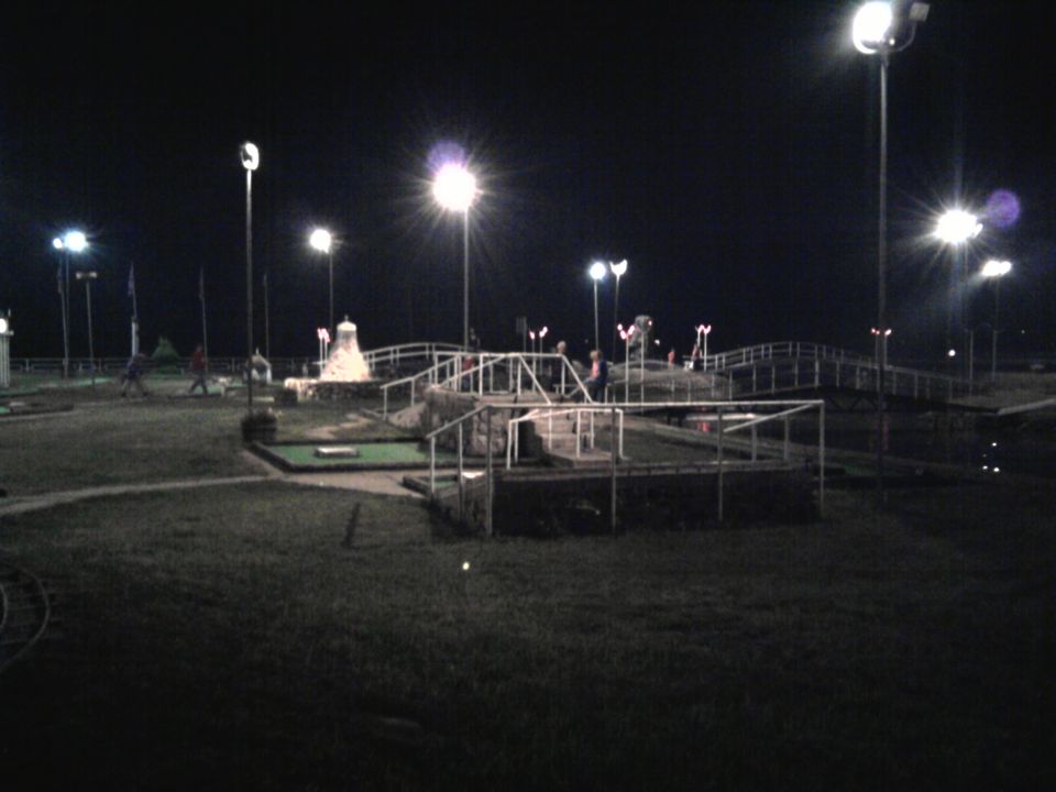 Mini golf course illuminated by lights at night