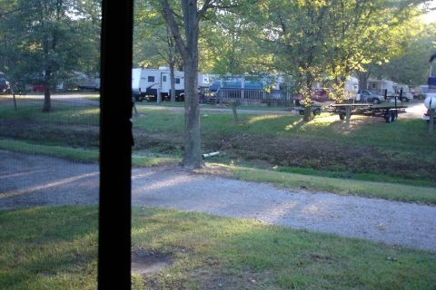2005 Chevrolet Silverado 3500 - A view of an RV park with multiple recreational vehicles and trailers under trees.
