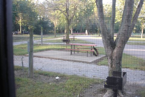 2005 Chevrolet Silverado 3500 - A campground scene features a picnic table and grill area surrounded by trees and gravel paths.