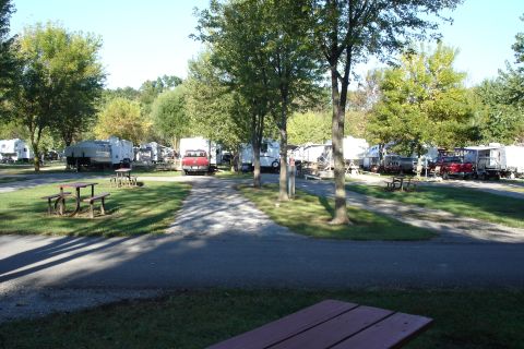 2005 Chevrolet Silverado 3500 - Multiple RVs and pickup trucks are parked at a campground on a sunny day.