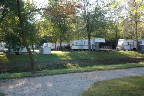 2005 Chevrolet Silverado 3500 - A campground scene shows several recreational vehicles parked in a wooded area.