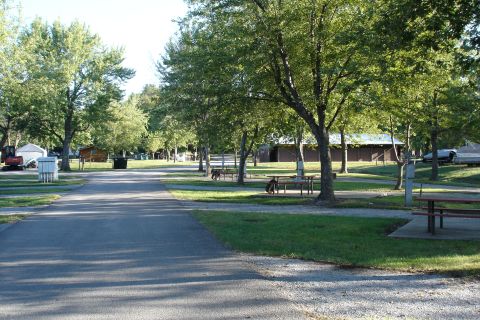 2005 Chevrolet Silverado 3500 - A campground scene with trees, picnic tables, and RVs visible. The image has a SUPERMOTORS watermark.