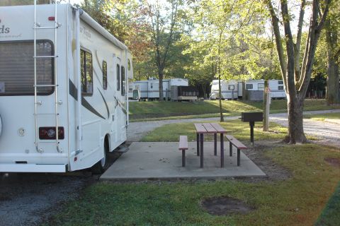 2005 Chevrolet Silverado 3500 - A campsite scene an RV, picnic table, and grill, with other RVs in the background.