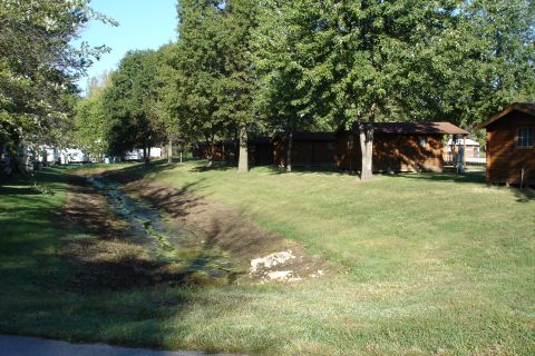 2005 Chevrolet Silverado 3500 - A campground scene with cabins, trees, and RVs visible in the distance.