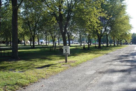2005 Chevrolet Silverado 3500 - A park scene with picnic tables and trees, a speed limit sign.