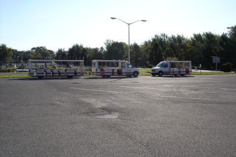 2005 Chevrolet Silverado 3500 - Multiple shuttle buses are parked in a lot on a clear day, with trees and a lamppost in the background.