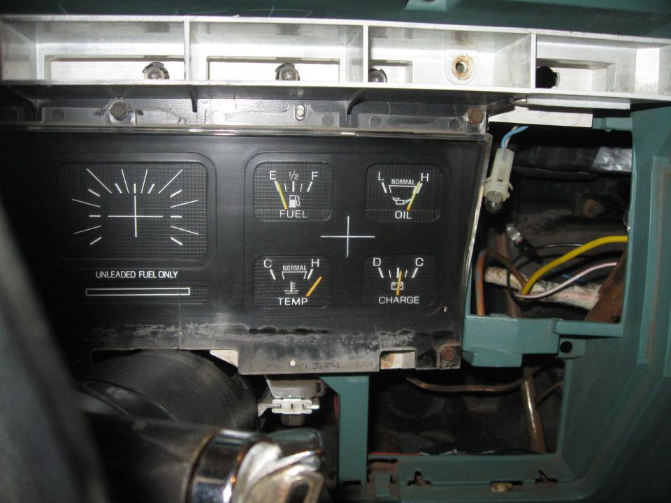 Dashboard gauges for fuel, oil, temperature, and charge. 'UNLEADED FUEL ONLY' is printed below the fuel gauge