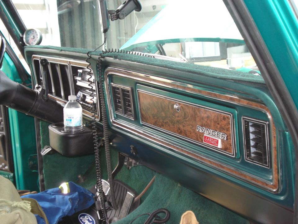Green dashboard with woodgrain trim, "Ranger Lariat" badge, and a water bottle in a cup holder