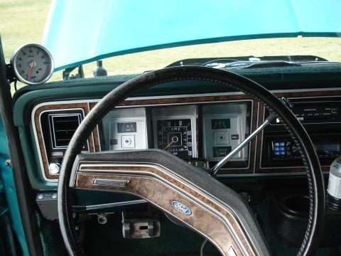 1979 Ford F-150 - The interior of a 1979 Ford F-150 shows the dashboard with its gauges and steering wheel, along with an aftermarket tachometer.