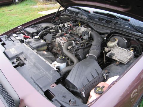 1991 Ford LTD Crown Victoria - The engine bay of a 1991 Ford Crown Victoria LTD is visible with the hood open.