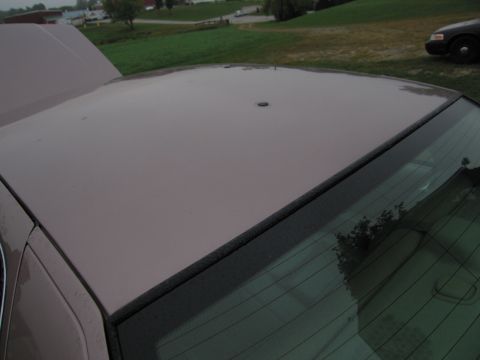 1991 Ford LTD Crown Victoria - The top of a car is shown with the hood open, and another vehicle is visible in the background.