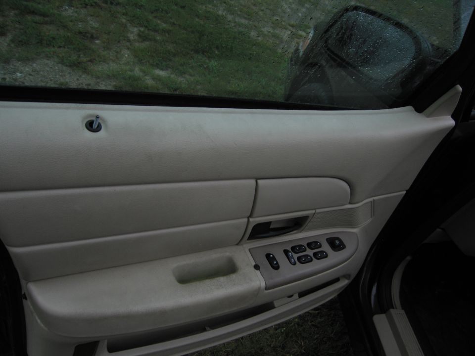 Interior door panel with power window controls and a lock knob