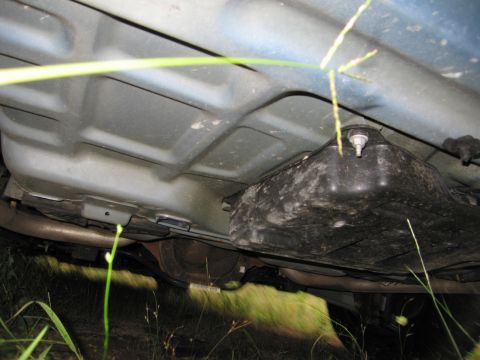 1991 Ford LTD Crown Victoria - The undercarriage of a vehicle is visible, showing the fuel tank and exhaust components.
