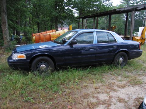 1991 Ford LTD Crown Victoria - This dark blue sedan, likely a Ford Crown Victoria from the early 2000s, is parked outdoors.