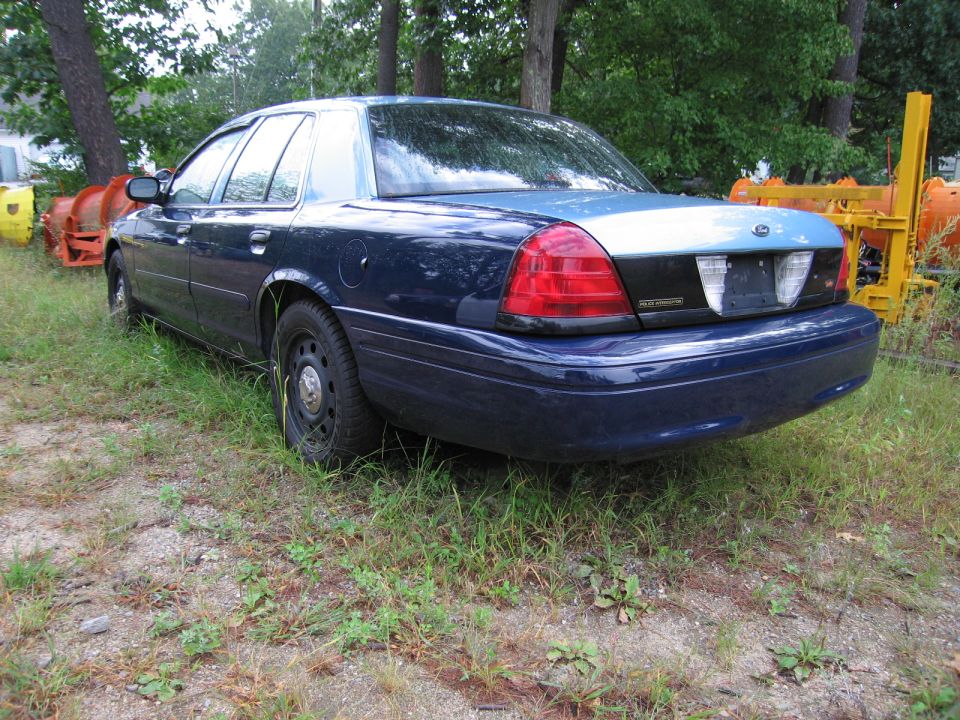 Dark blue sedan, rear view. License plate area is blank