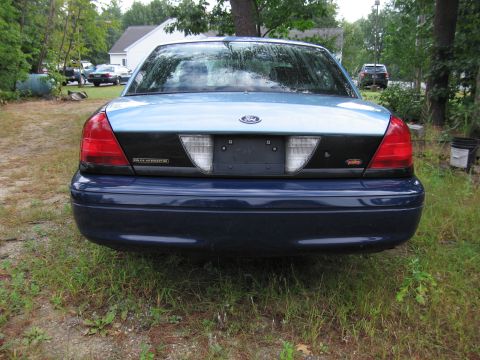 1991 Ford LTD Crown Victoria - This Ford Crown Victoria Police Interceptor is parked in a grassy area with trees in the background.