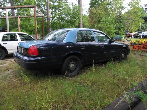 1991 Ford LTD Crown Victoria - A 1991 Ford Crown Victoria LTD sedan, painted dark blue with a light blue roof, sits in a grassy lot beside another vehicle.
